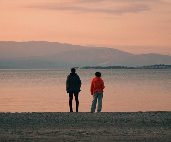 A person meditating peacefully by a window at sunrise.